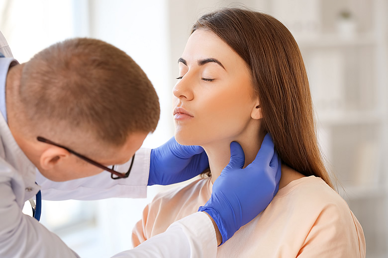 Doctor examining woman's thyroid gland