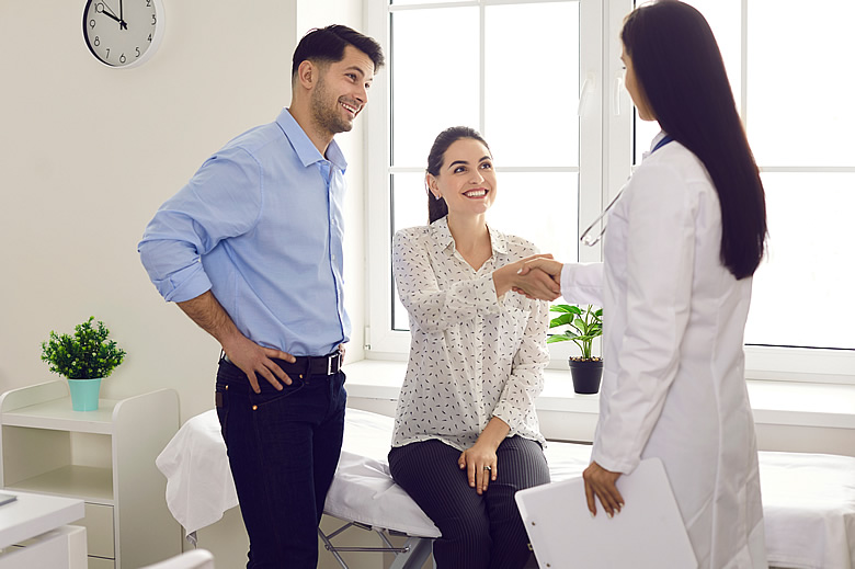 Doctor with Young Couple In Her Office